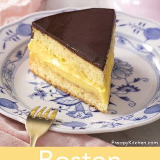 Boston cream pie next to a golden fork.