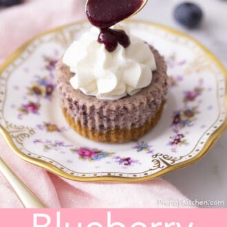 Blueberry reduction pouring onto a Mini Blueberry Cheesecake