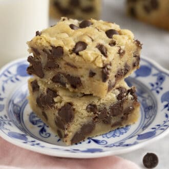 Two chocolate chip cookie bars on a blue and white plate.