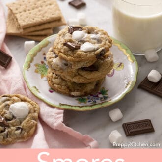 A stack of smores cookies next to a glass of milk.
