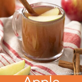 Pinterest graphic of a glass mugs of apple cider with apple slices and a cinnamon stick.