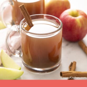 Pinterest graphic of amber colored apple cider in glass mugs.