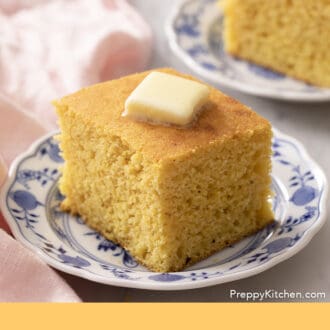 Pinterest graphic of two pieces of cornbread on small plates with butter on top.