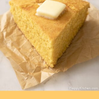Pinterest graphic of a wedge-shaped piece of cornbread on parchment paper.