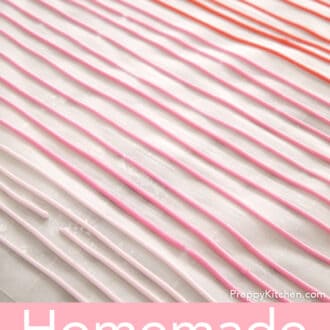 Pink piped homemade sprinkles drying on parchment paper.