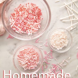 three glass bowls of pink sprinkles.