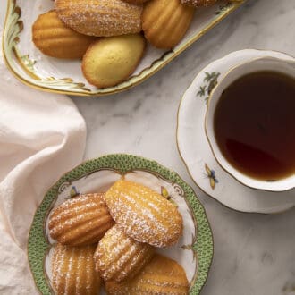 Madeleines next to tea on a marble counter.