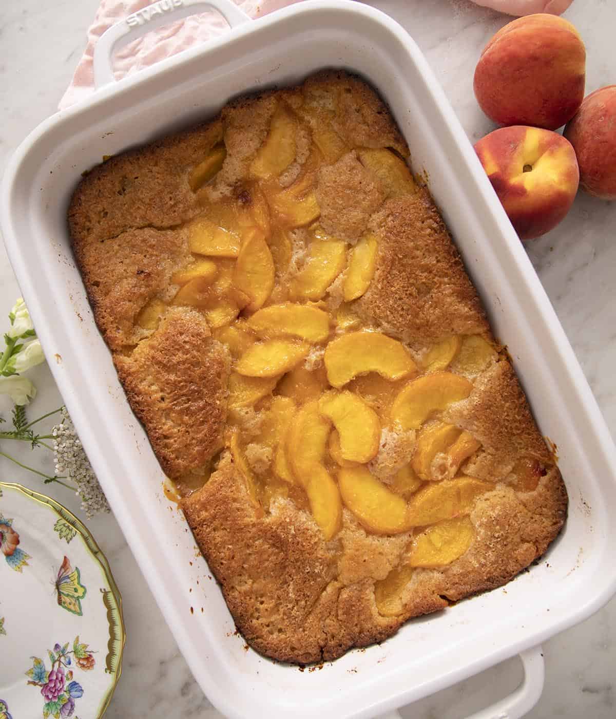 Peach cobbler in a white rectangular baking dish.