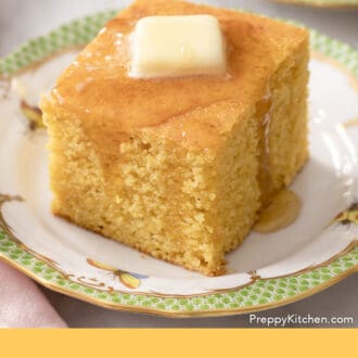 Pinterest graphic of a piece of cornbread on a green and white plate with melted butter on top.