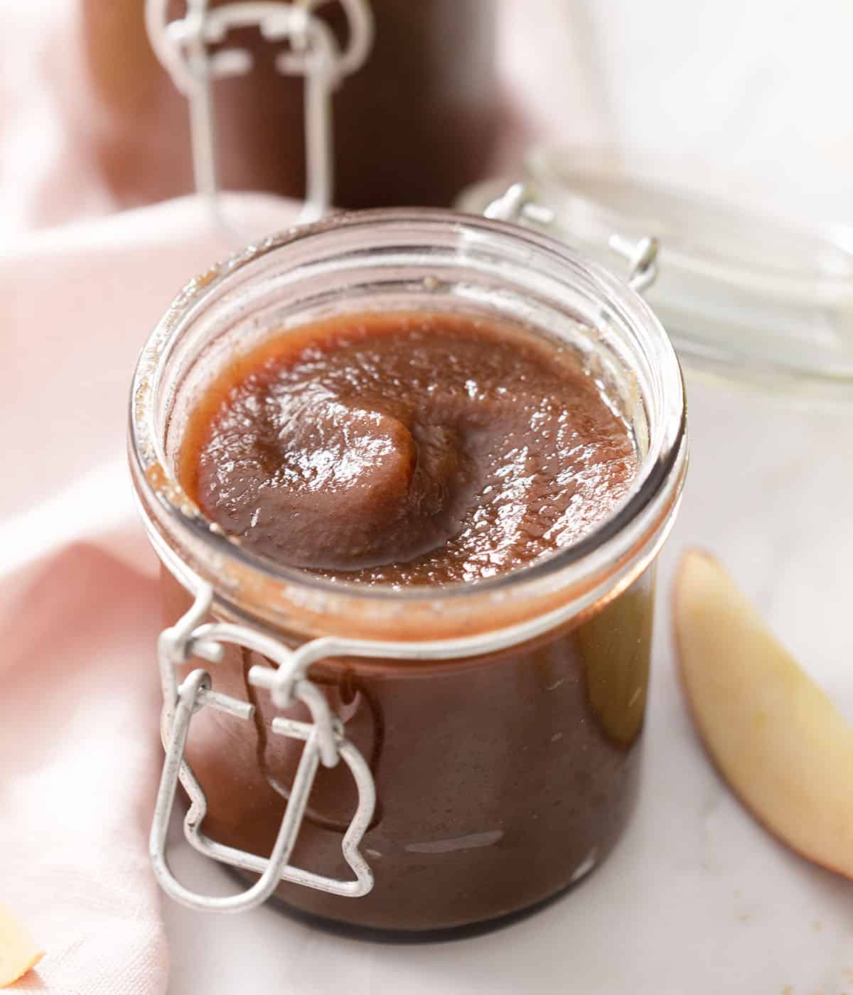 A mason jar with apple butter inside.