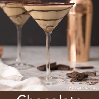 Pinterest graphic of two chocolate martinis with a swirls of chocolate syrup with broken chocolate pieces scattered around.