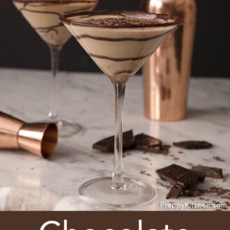 Pinterest graphic of two chocolate martinis with a swirls of chocolate syrup on a marble counter.