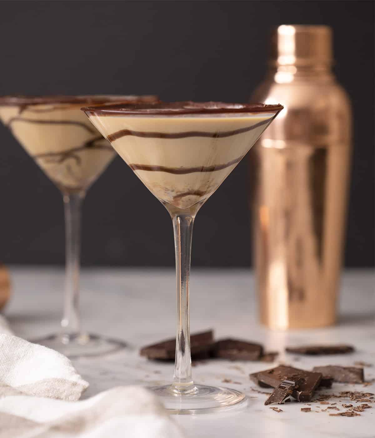 Two chocolate martinis in glasses with swirls of chocolate inside.