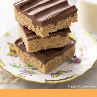 Pinterest graphic of three scotcheroos stacked on a porcelain plate. Glass of milk in the background.