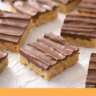 Pinterest graphic of a group of scotcheroos on a wrinkled parchment.