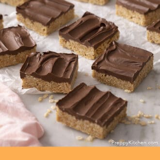 Pinterest graphic of a group of scotcheroos arranged on parchment paper.