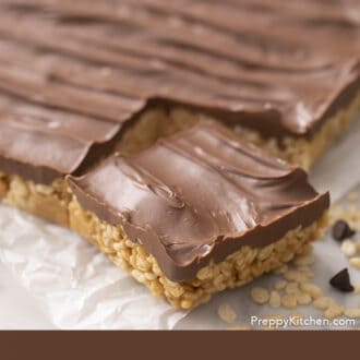 Pinterest graphic of a block of scotcheroos with one piece cut out on a counter.