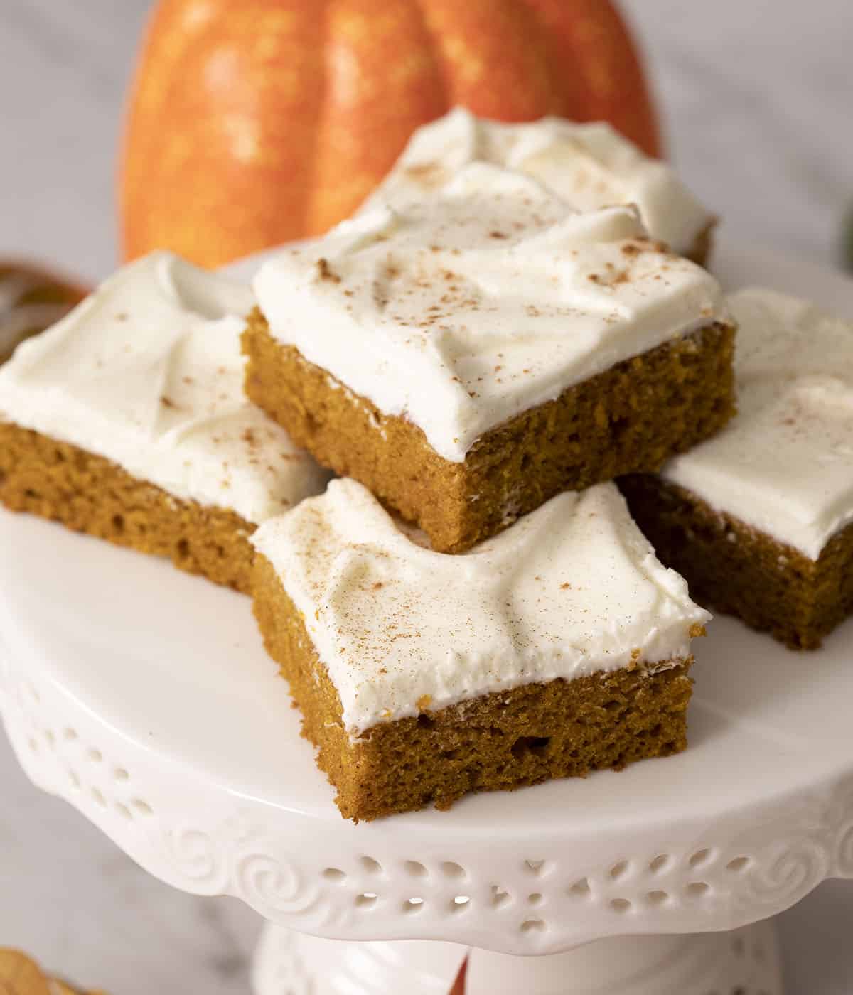 Pumpkin bars on a white cake stand.