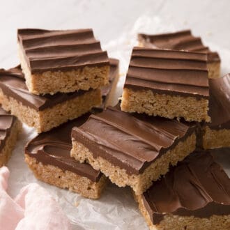 Pinterest graphic of a group of scotcheroos with chocolate on top on a marble surface.