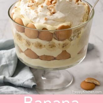Pinterest graphic of a banana pudding in a glass trifle dish with a spoon tucked in.