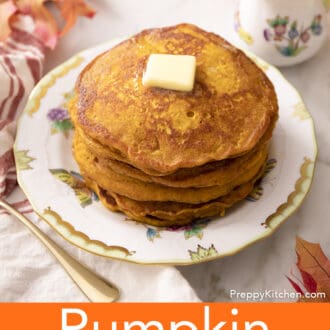 A stack of pumpkin pancakes with butter on a porcelain plate.