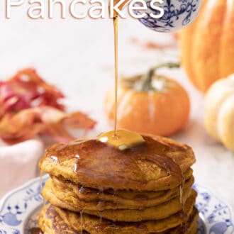 Pumpkin pancakes on a plate with pumpkins in the background.