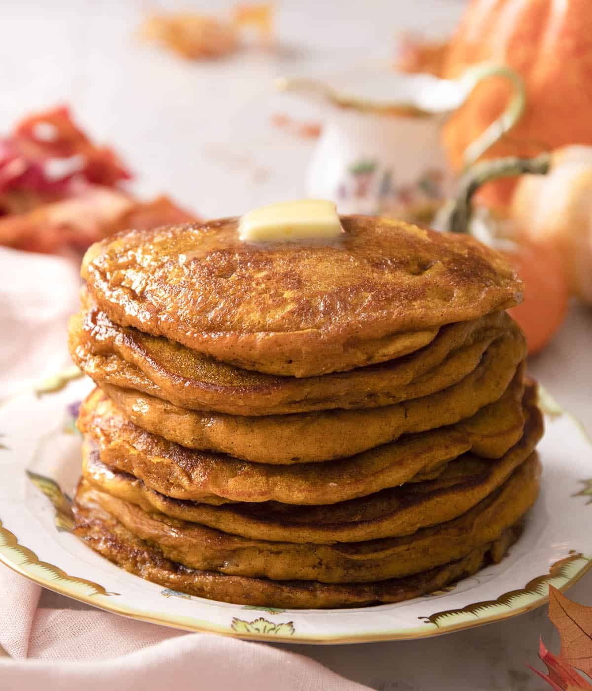 A stack of pumpkin pancakes on a blue and white plate.