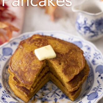 A stack of three pumpkin pancakes with a piece cut out.