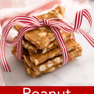 Pinterest graphic of pieces of peanut brittle stacked and tied in red and white ribbon.
