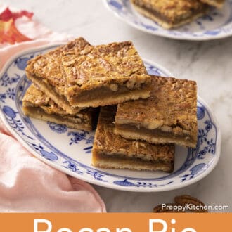 Pinterest graphic of pecan pie bars stacked on a blue and white serving tray.