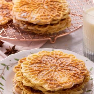 A pinterest graphic of Pizzelle cookies in a plate and some in the background on a cooling rack.