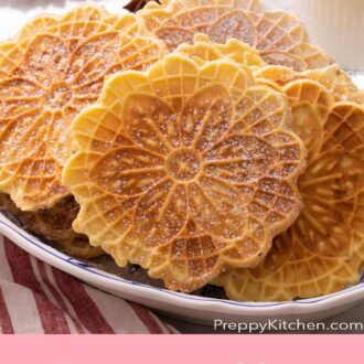 A pinterest graphic of Pizzelle cookies with a light dusting of powdered sugar in a plate.