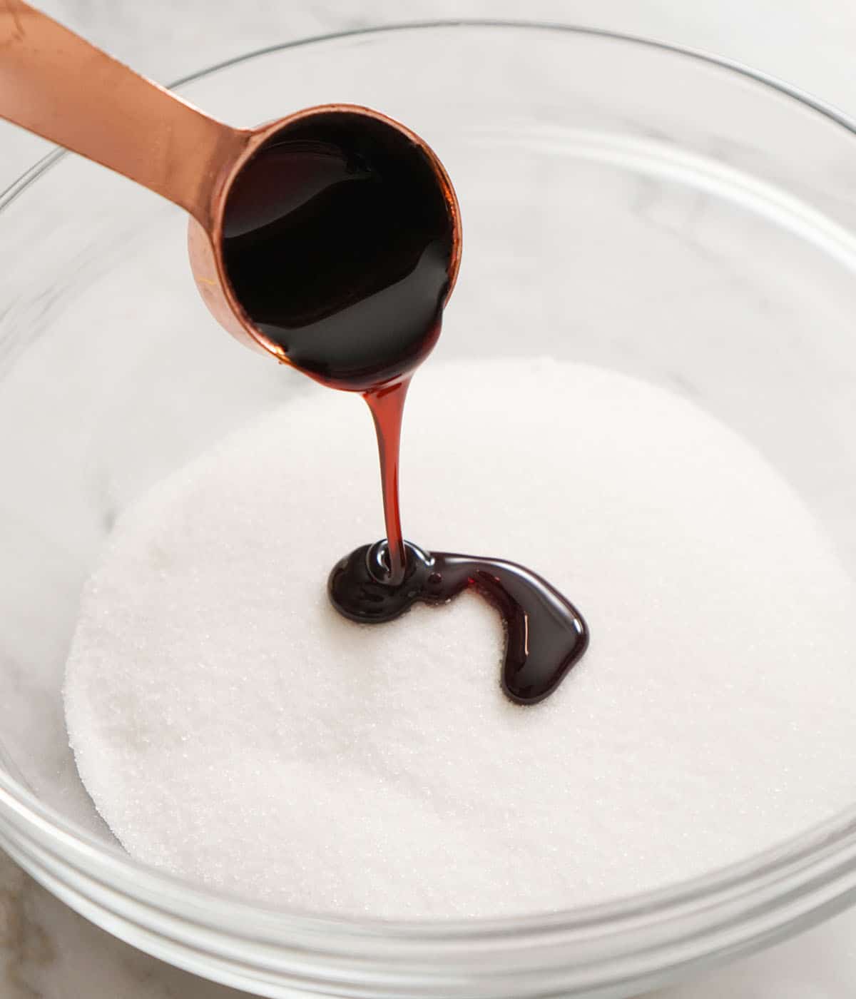 Molasses pouring into a bowl for granulated sugar.