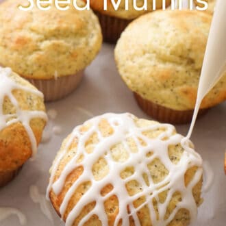 Pinterest graphic of a group of lemon poppy seed muffins on a piece of parchment paper, one being drizzled with lemon glaze.