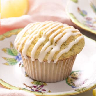 A lemon poppy seed muffin with lemon glaze on a small plate.