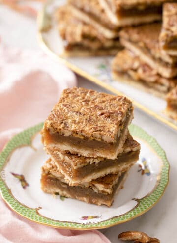 Three pecan pie bars on a small plate.