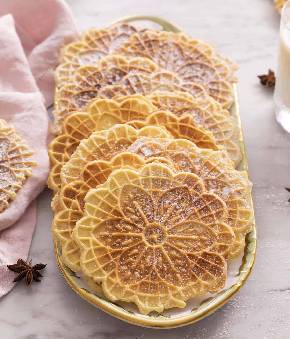 Multiple pizzelle cookies on a platter.