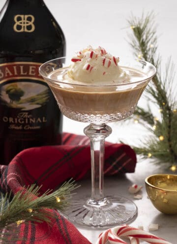 A Baileys affogato in a crystal glass with crushed candy cane on top.