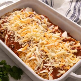 Pinterest graphic showing enchiladas before baking, topped with shredded cheese.