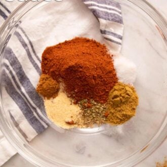 Pinterest graphic showing enchilada sauce spices in a glass bowl.