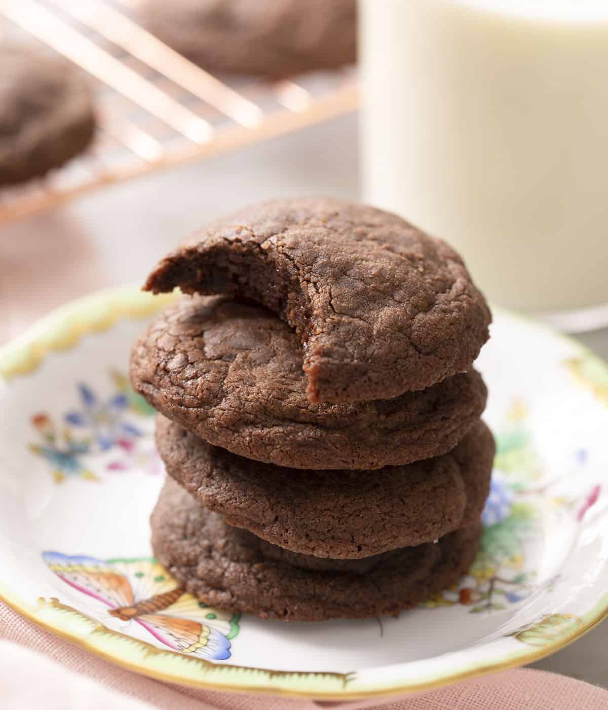A stack of nutella cookies on a plate one with a bite out
