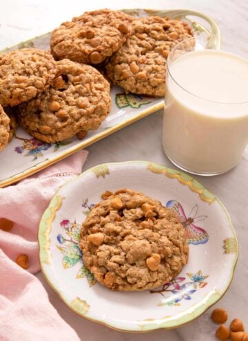 Oatmeal scotchies on plates with a glass of milk.