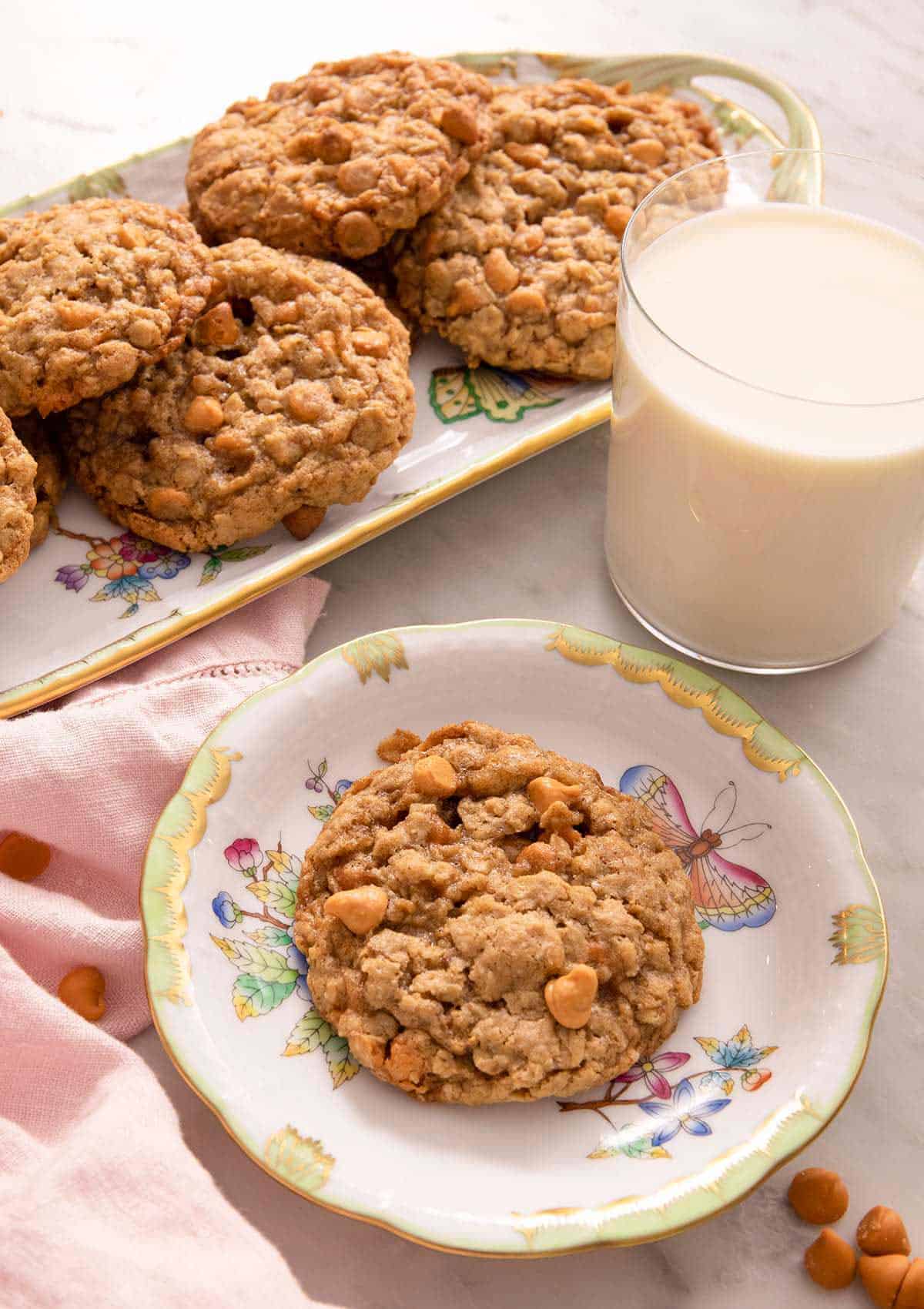 Oatmeal scotchies on plates with a glass of milk.