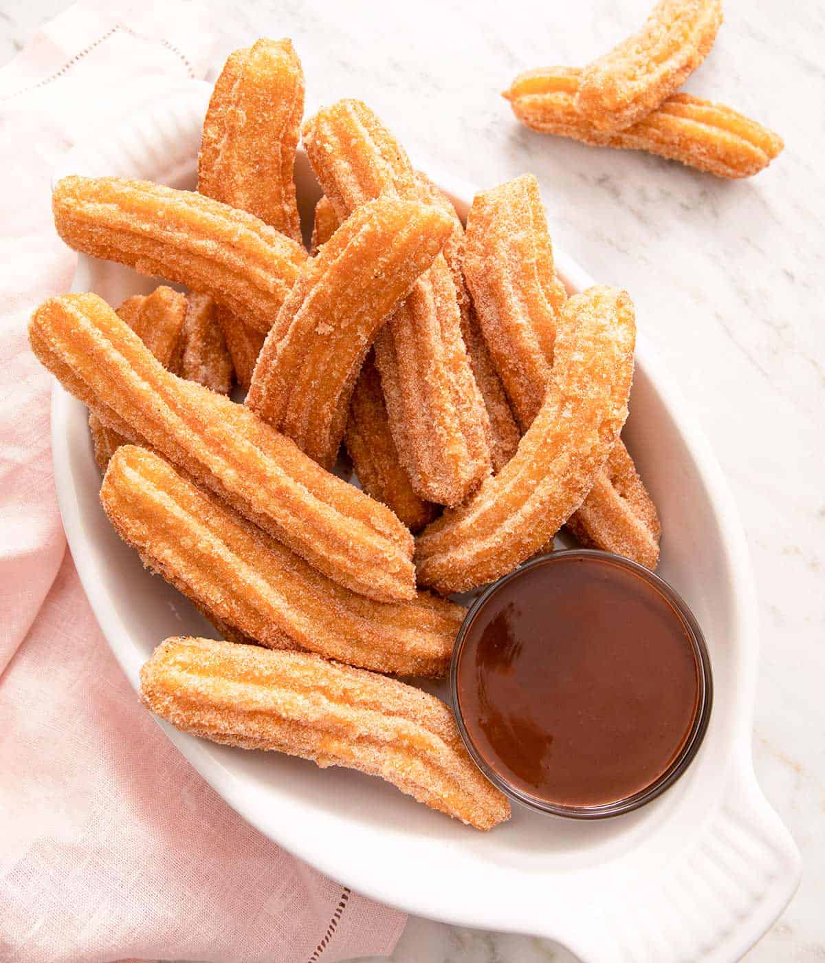 An overhead shot of churros on a serving plate