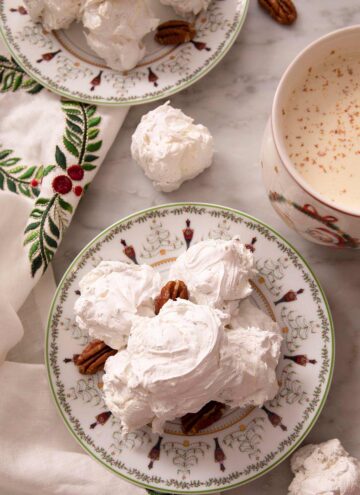 An overhead shot of Divinity candy on a serving plate. A mug of hot chocolate on the side.
