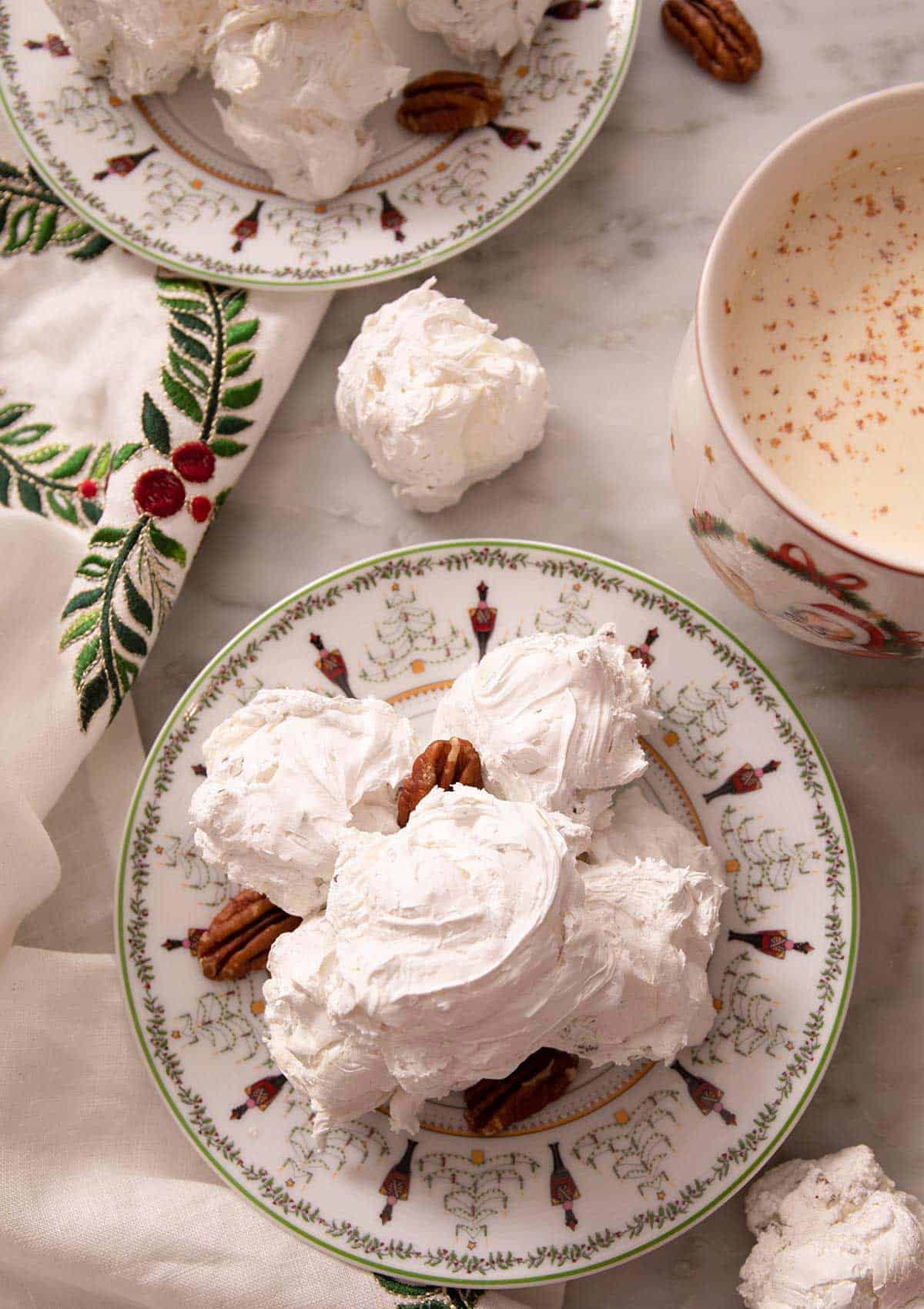 An overhead shot of Divinity candy on a serving plate. A mug of hot chocolate on the side.