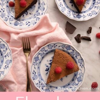 A pinterest graphic of three plated slices of flourless chocolate cake topped with raspberries.
