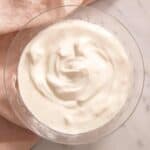 A close up of the result of the how to make sour cream tutorial in a glass bowl.
