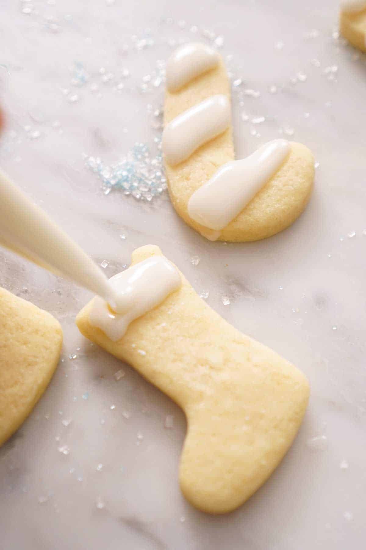 Christmas shaped cookies getting piped with icing