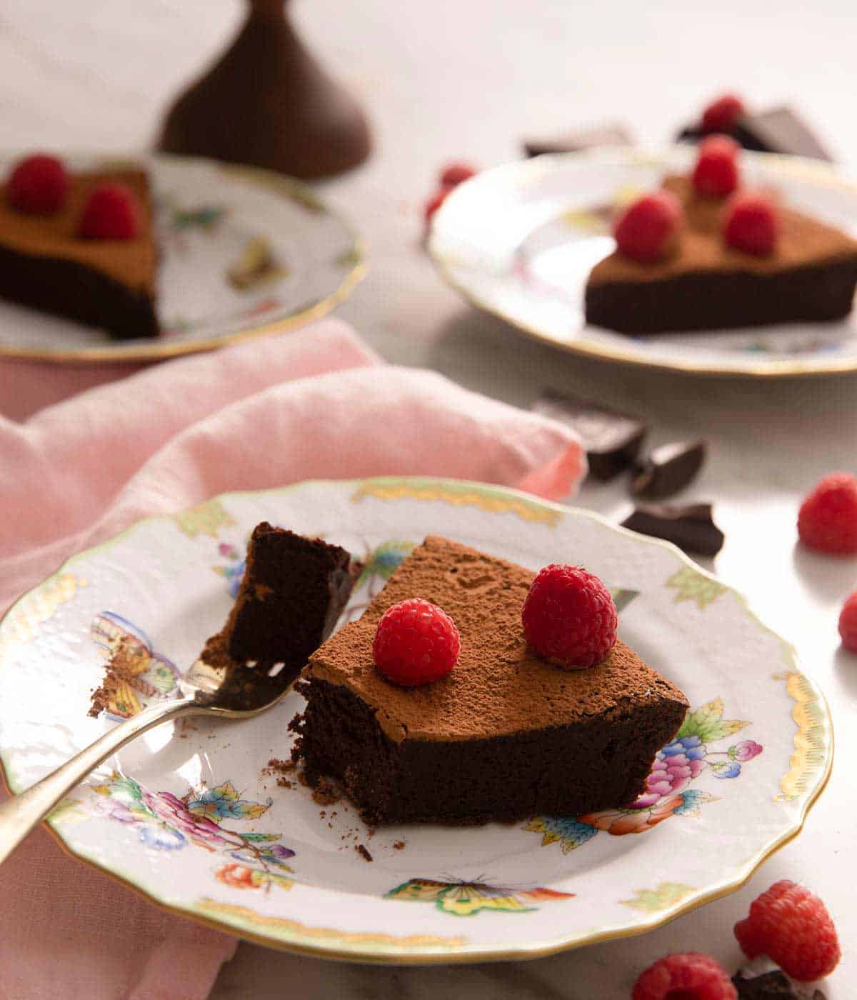 A slice of chocolate cake on a plate with a bite taken out.